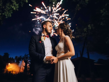 Wedding fireworks. Bride and groom hugging in the night on firework and salute background on night sky, enjoying the happiest day in life .
